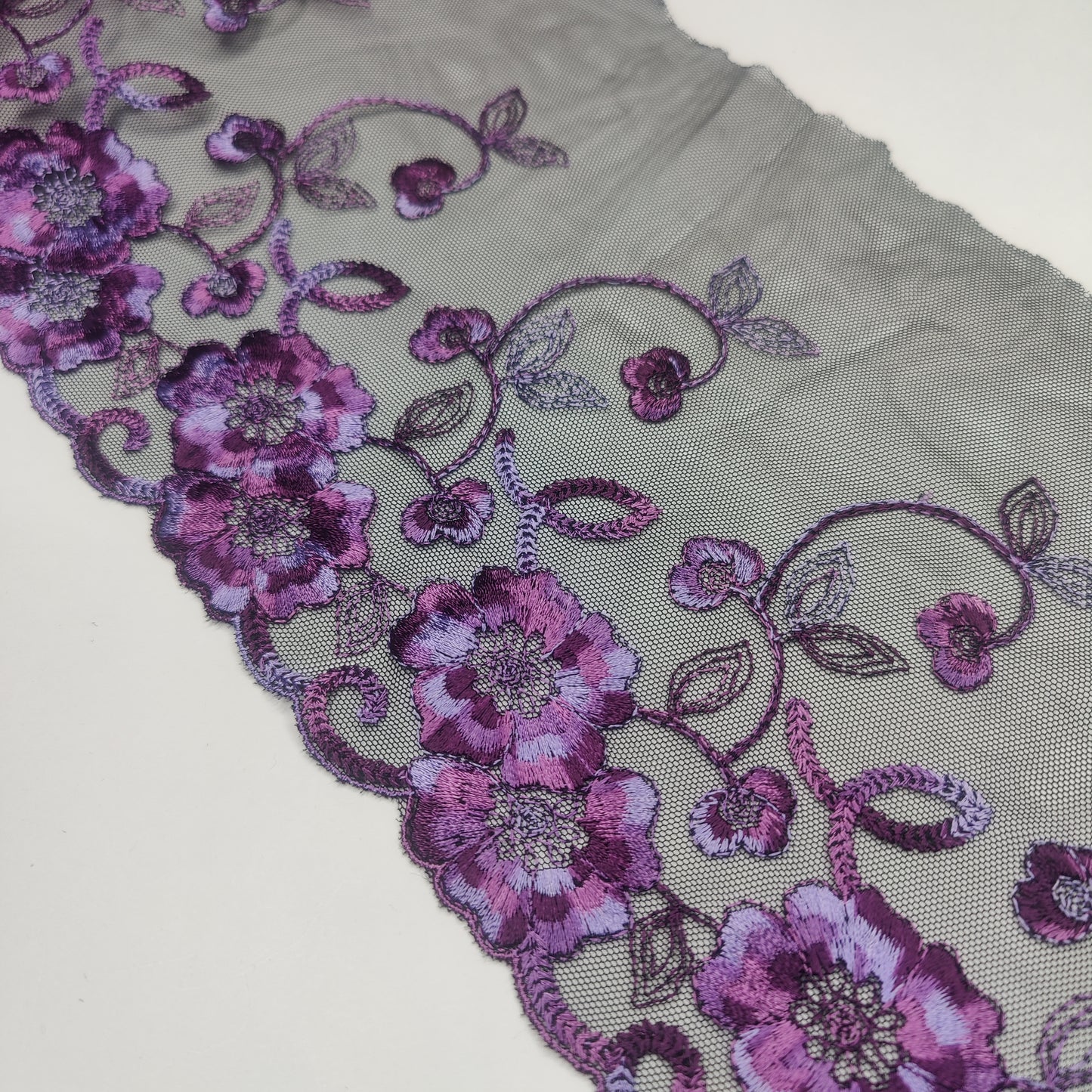 Dentelle brodée de 1 m de large en noir et violet. Bordure de broderie inélastique. IDstx9